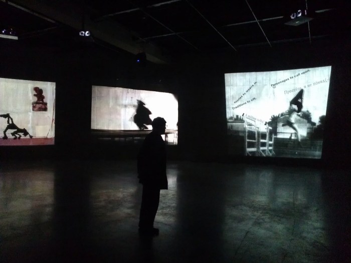 A viewer engrossed in the Kentridge videos